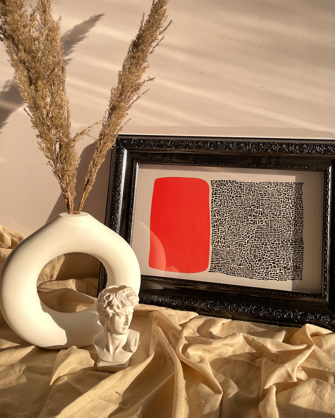 Close-up of black canvas wall art in decorative packaging with brown paper and ribbon