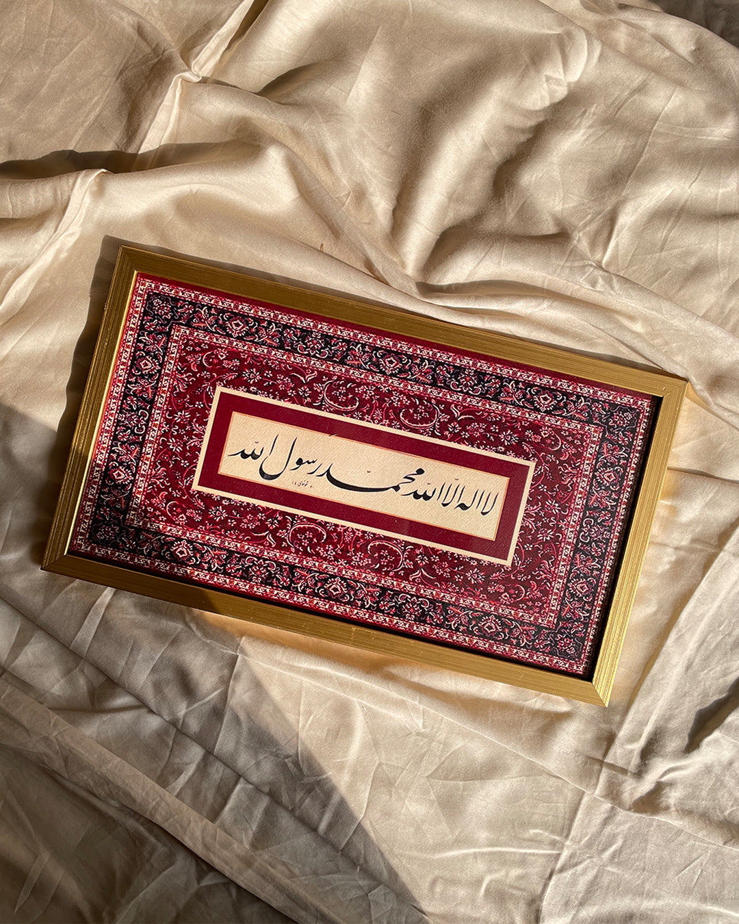 Front view of gold Kalma frame placed on textured background