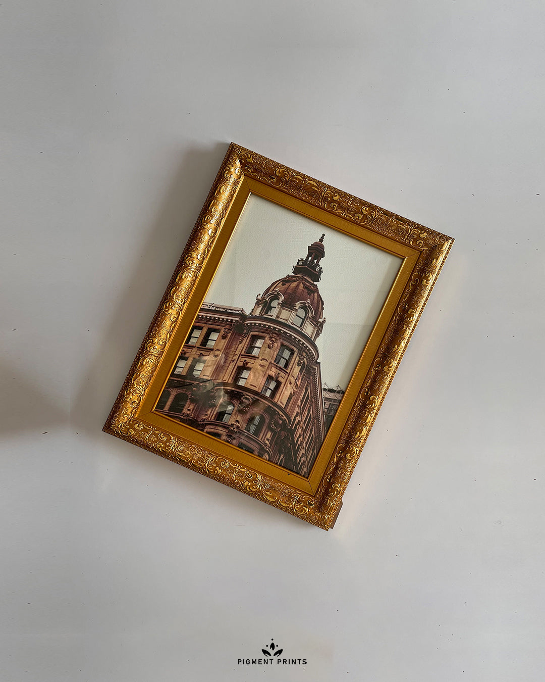Decorative gold picture frame displayed on wooden table