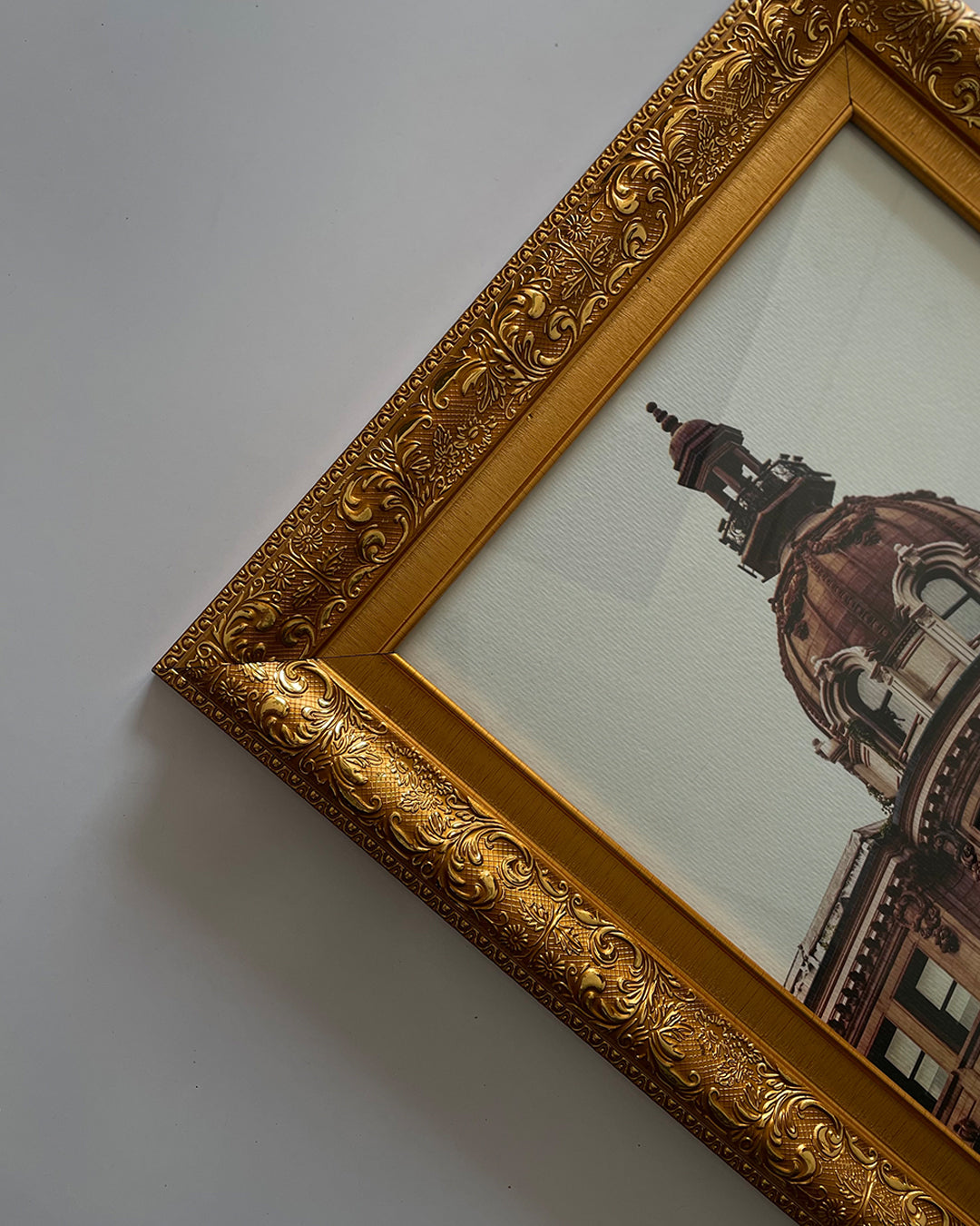 Luxe gold frame displayed on light-colored wall