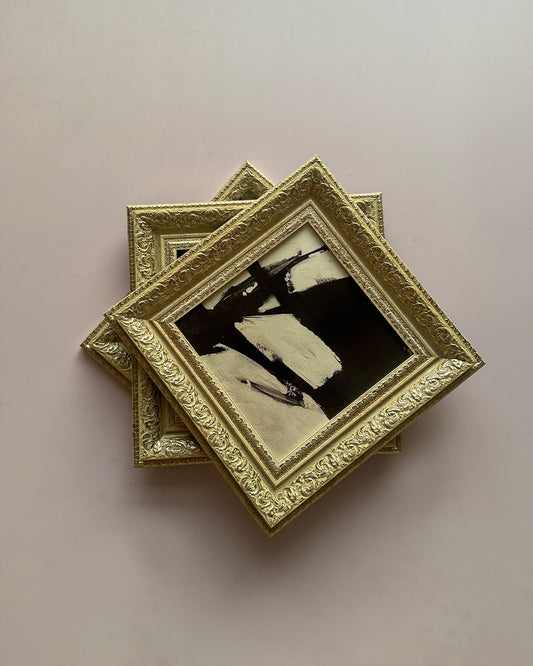 Top view of beige gold framed wall art on white background