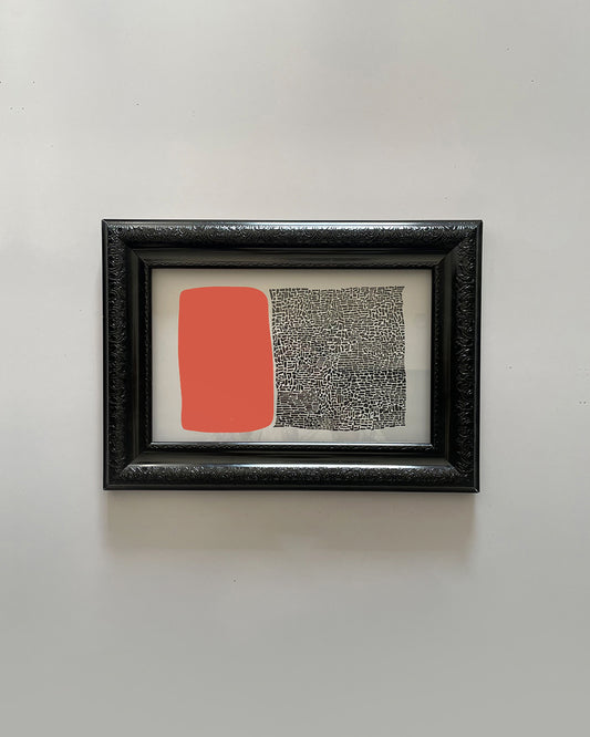 Framed abstract wall art featuring a bold red and white shape on black canvas