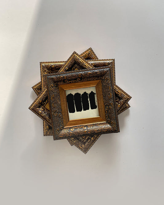 GOLD STAIN wall art in decorative wooden frame on white wall
